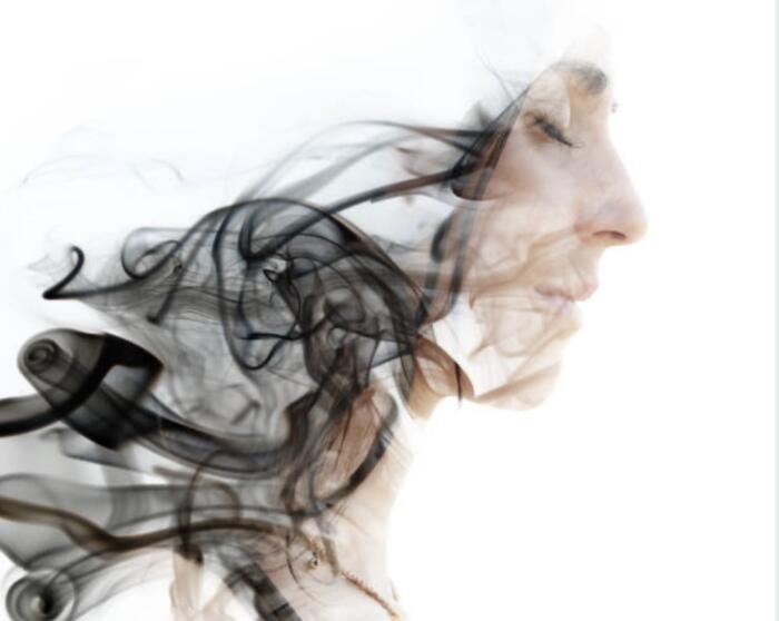 Profile of a face emerging from swirling smoke