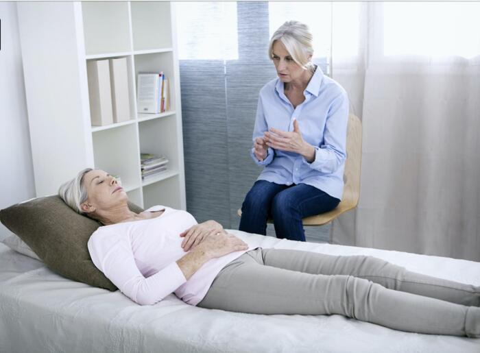 A facilitator guiding a client who rests comfortably during a session